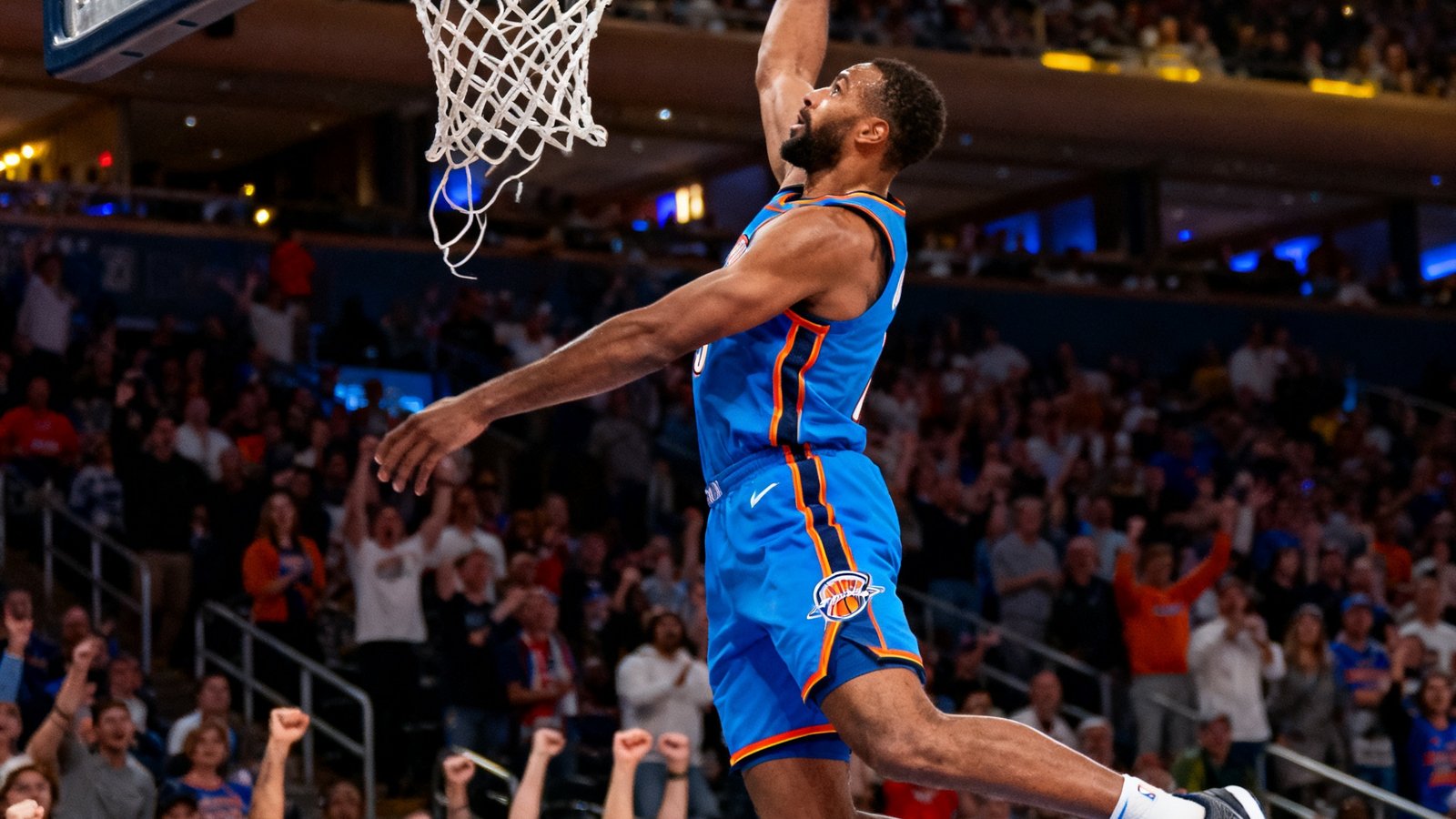 NBA赛场高清转播画面，一位球星飞身扣篮，篮筐震颤，全场观众起立欢呼